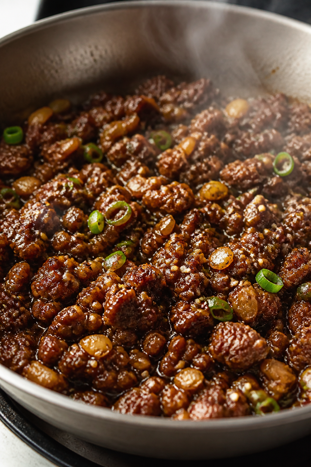 Close-up detail: Glossy Korean-style ground beef sizzling in a wide skillet right after the sauce is