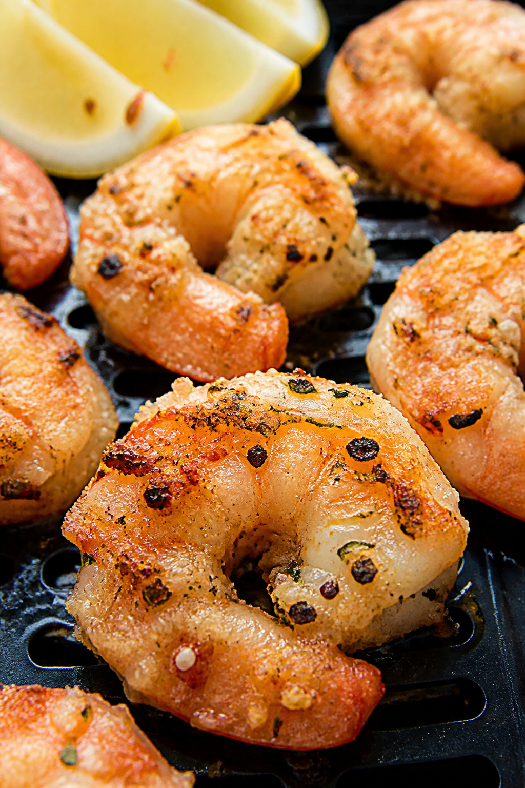 Close-up detail shot of air-fried garlic Parmesan shrimp just out of the basket: plump pink shrimp w
