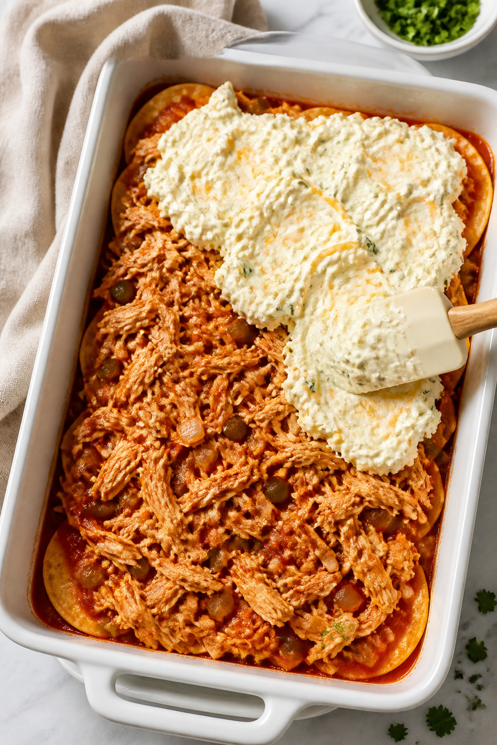 Cooking process, close-up: A 9x13-inch baking dish mid-assembly for Cottage Cheese Chicken Enchilada