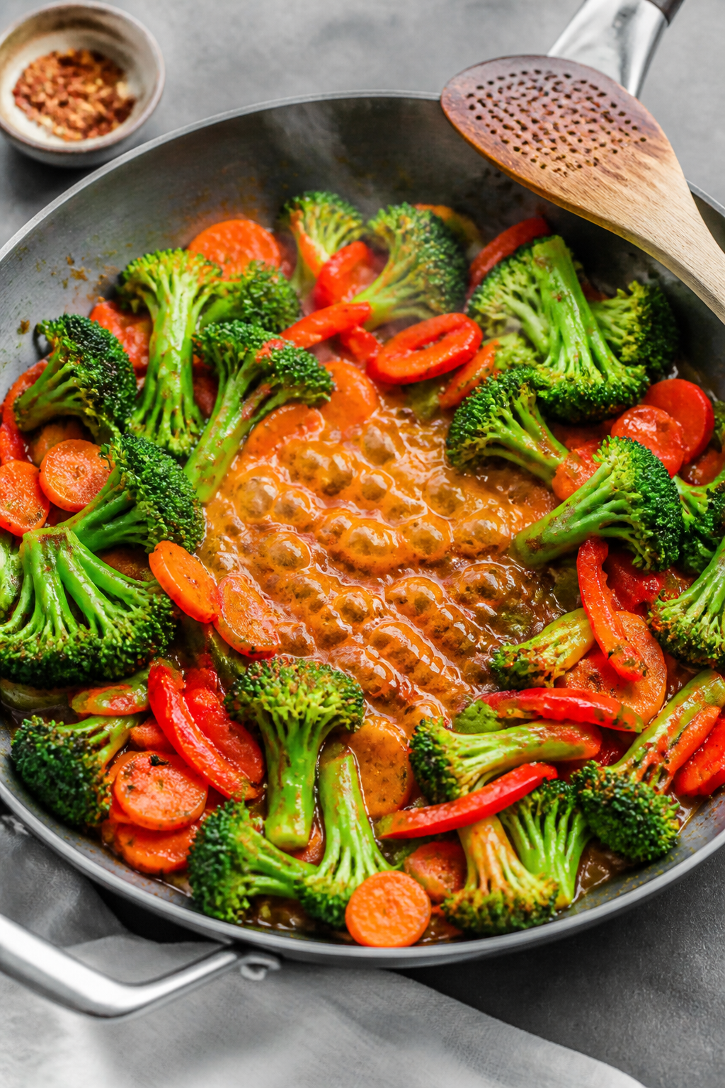 Cooking process: Stir-fry moment in a wide skillet—crisp-tender broccoli florets and thin carrot c