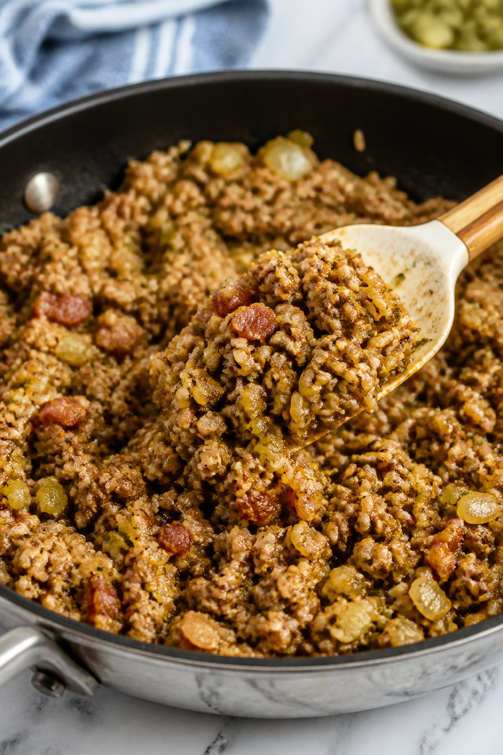 Cooking process: The browned beef mixture in a large skillet mid-stir, showing crumbly lean beef coa
