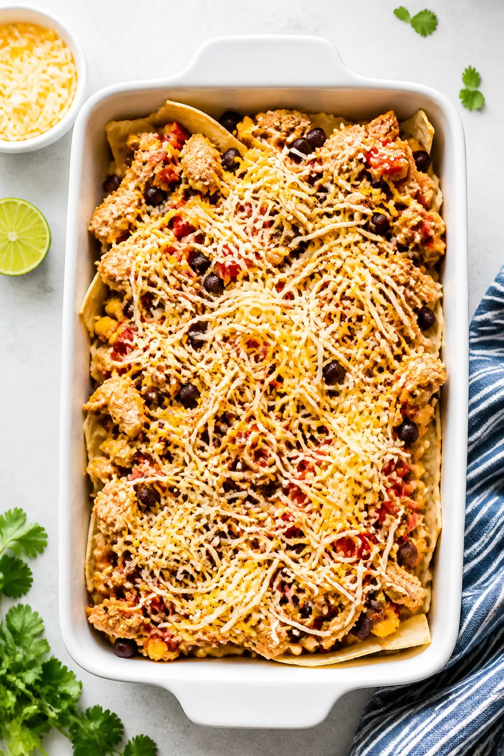 Layering moment, top view: Overhead shot of the casserole mid-assembly in a 9x13 baking dish—first