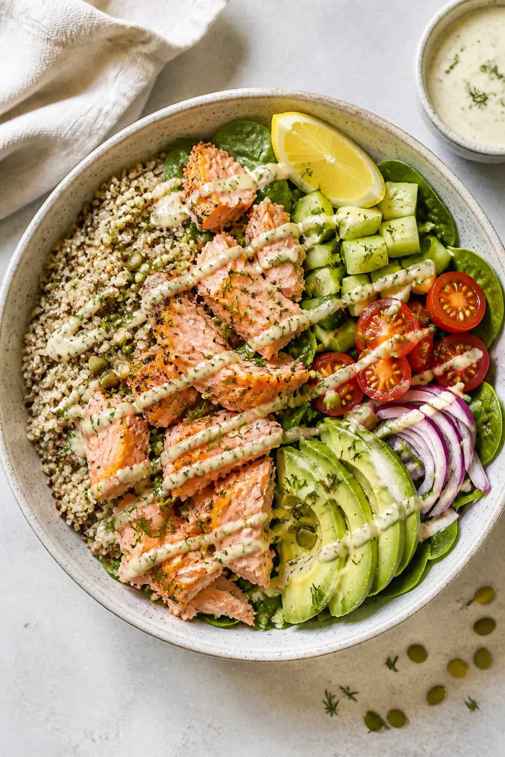 Tasty top view: Overhead shot of Healthy Salmon Power Bowl assembled in a wide ceramic bowl—half q